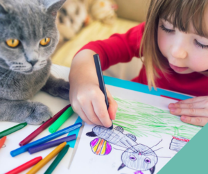 Cat keeping child occupied whilst colouring in