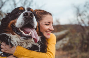 Dog and owner hugging - lady in orange